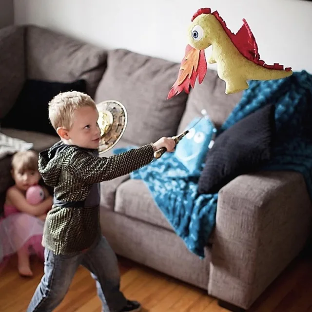 Enfant qui joue au chevalier face à la peluche dragon des TrOnches.
